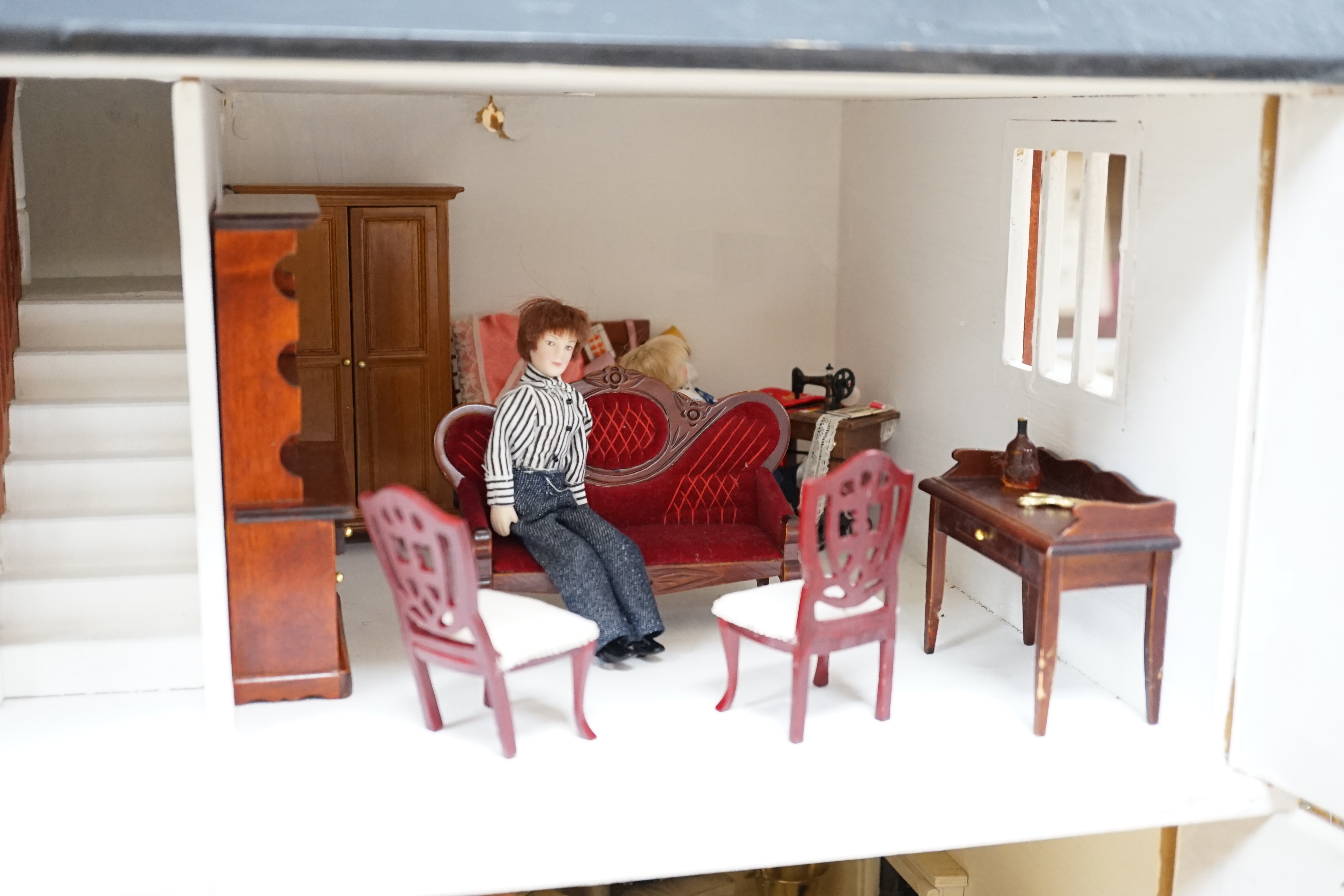 A painted doll's house with dolls and furniture, dolls house 78.5cm wide, 67cm high